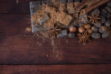 Çikolata, baharatlar, kaşık kakao, tarçın, fındık koyu renkli ahşap ile