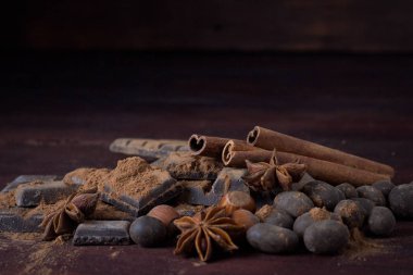 Çikolata, baharatlar, kaşık kakao, tarçın, fındık koyu renkli ahşap ile