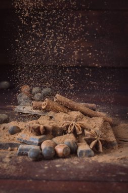 Çikolata, baharat, kakao, kaşıkla Metal süzgeç, fındık üzerinde Dar