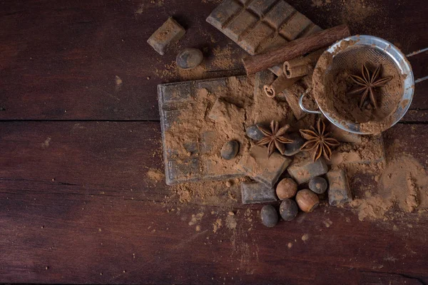 Çikolata, baharat, kakao, kaşıkla Metal süzgeç, fındık üzerinde