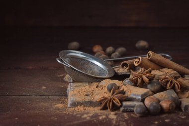 Çikolata, baharat, kakao, kaşıkla Metal süzgeç, fındık üzerinde