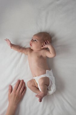 Biraz bebeğim beze, bebeğim, üzerinde beyaz bir yatak ve bir kadın yatıyor