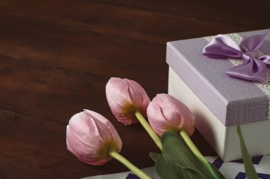 Lale, koyu ahşap arka plan üzerinde hediye kutusu