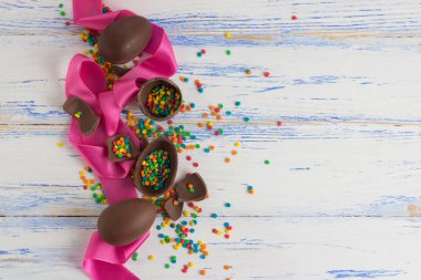 Paskalya çikolata yumurta, pembe bant, eski üzerinde çok renkli tatlılar