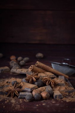 Çikolata, baharat, kakao, kaşıkla Metal süzgeç, fındık üzerinde
