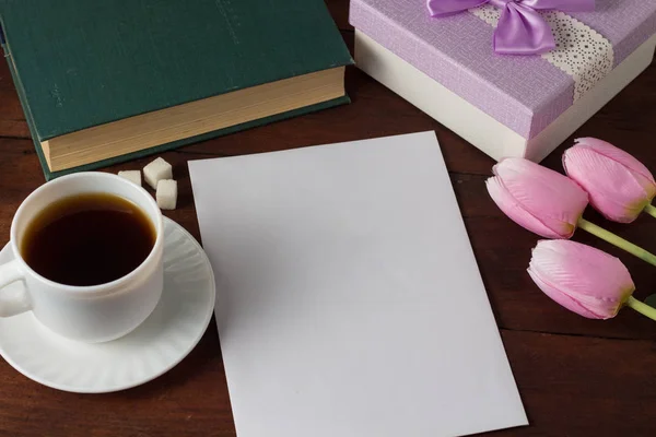 Cup with Coffee, Book, Gift, Tulips, White Paper Sheet on a Dark