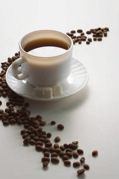 White Cup with Coffee, Coffee Beans on a White Background