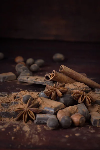 Czekolada, przyprawy, łyżka z kakao, orzechów laskowych na ciemne drewniane Bac — Zdjęcie stockowe