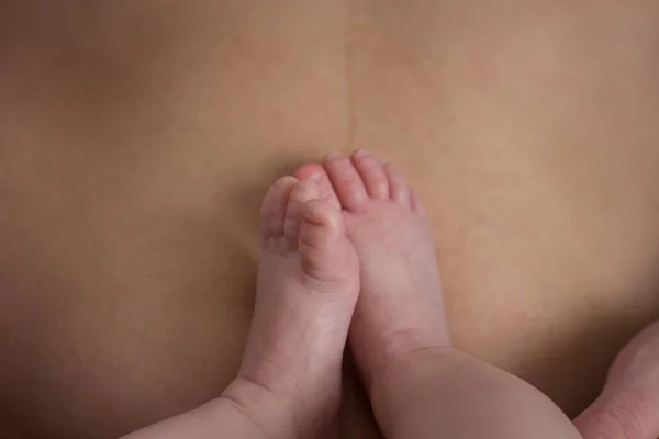 Patas de bebé en el vientre de la madre. El concepto de una familia feliz —  Fotos de Stock