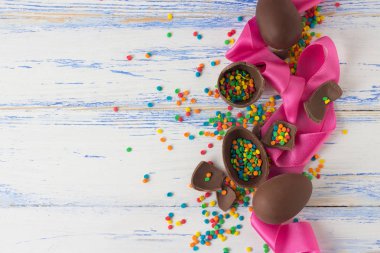 Paskalya çikolata yumurta, pembe bant, eski üzerinde çok renkli tatlılar