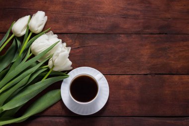 Beyaz Laleler ve bir fincan kahve koyu ahşap arka plan üzerinde. Co