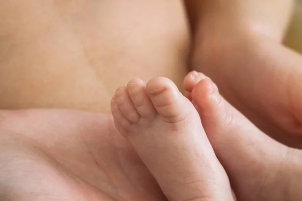 De benen van de baby op de buik van de moeder — Stockfoto