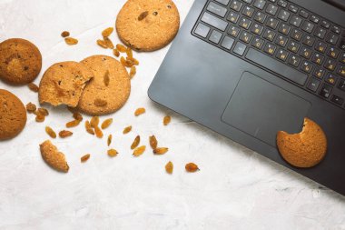 Ev yapımı yulaf ezmeli kurabiye ve hafif bir beton Backgrou üstünde Laptop