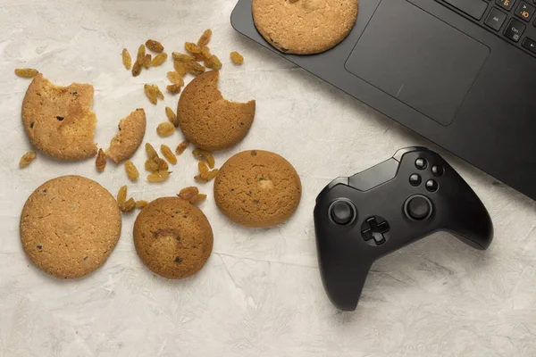 Concept gameplay, Gamepad, Cookies, Laptop on a light background