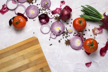 Baharatlar, kara biber, sarımsak, soğan, kesme tahtası ve domates. 