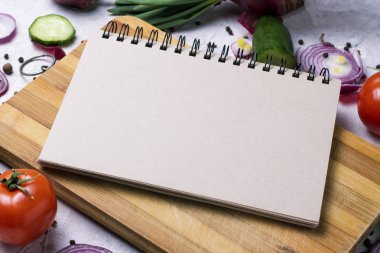 Taze çiftlik sebze kesme tahtası ve bir defter ile çevresinde