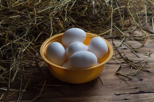 Fehér csirke tojás egy sárga lemez egy fából készült háttér — Stock Fotó