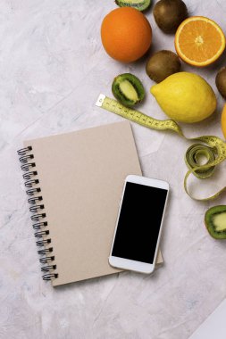 Telefon, not defteri ve taze organik meyve. Ağırlık l kavramı