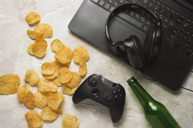 Dizüstü bilgisayar, Gamepad, kulaklık, patates cipsi, şişe bira bir l ile ilgili