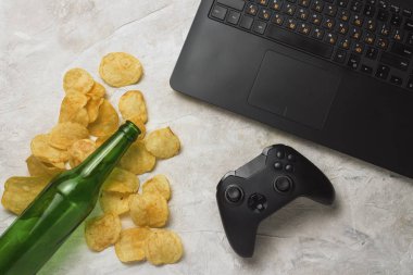 Dizüstü bilgisayar, Gamepad, patates cipsi, şişe bira hafif bir taş b