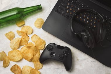 Dizüstü bilgisayar, Gamepad, kulaklık, patates cipsi, şişe bira bir l ile ilgili