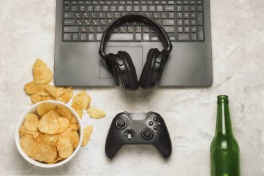 Dizüstü bilgisayar, Gamepad, kulaklık, patates cipsi, şişe bira bir l ile ilgili