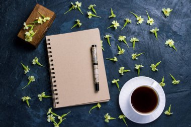 Fincan kahve, dizüstü bilgisayar, bir ahşap kutu ve koyu mavi çiçekler