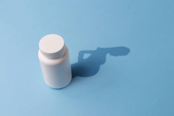 Garrafa de plástico com comprimidos e sombra na forma de uma grávida — Fotografia de Stock
