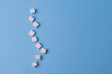 Küp şeker mavi bir arka plan üzerinde. Şeker öldürür kavramı 