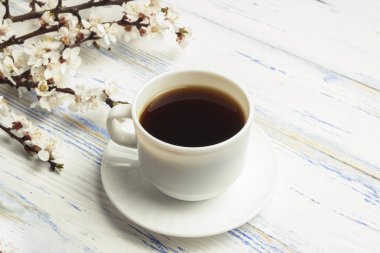 Kiraz çiçekleri ile ve beyaz fincan sade kahve o delikanlı