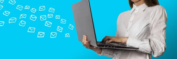 Chica con el ordenador portátil y muchos correos electrónicos voladores en un backgrou azul claro — Foto de Stock