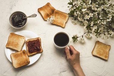 Bir fincan kahve, reçel, tost, Bahar dalları tutan el