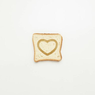 Beyaz zemin üzerinde bir kalp ile tost dilim