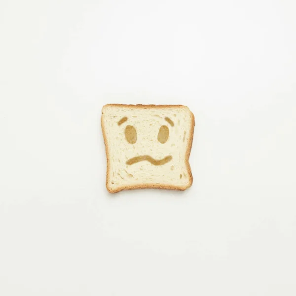 Rebanada Pan Tostado Con Una Sonrisa Triste Sobre Fondo Blanco — Foto de Stock