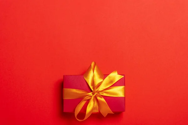 Κουτί δώρου σε κόκκινο φόντο. Χριστουγεννιάτικη ιδέα. Επίπεδο lay, πάνω όψη — Φωτογραφία Αρχείου