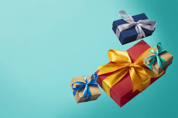 Boîtes-cadeaux volantes sur fond bleu. Concept de vacances, Noël. Lévitation. Des objets en l'air. Couché plat, vue du dessus — Photo