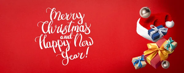 Vliegende Kerstman hoed, geschenkdoos en kerstversiering op een rode achtergrond. Vakantie concept, kerst. Levitatie. Items in de lucht. Vlakke lay, bovenaanzicht. Banner — Stockfoto