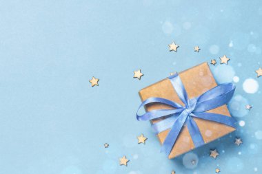 Dekoratif yıldızlı mavi kurdeleli hediye kutusu ve bokeh. Sevdiğin biri için hediye konsepti, tatil. Düz yatış, üst görünüm