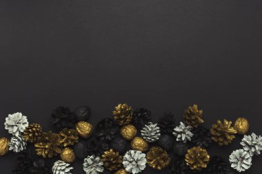 Çam kozalakları ve fındıklar altın, siyah, beyaz renklerle boyanmış 