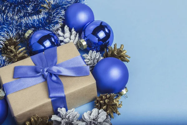 Dárková krabička s modrou stuhou, vánoční ozdobou, míčky a — Stock fotografie