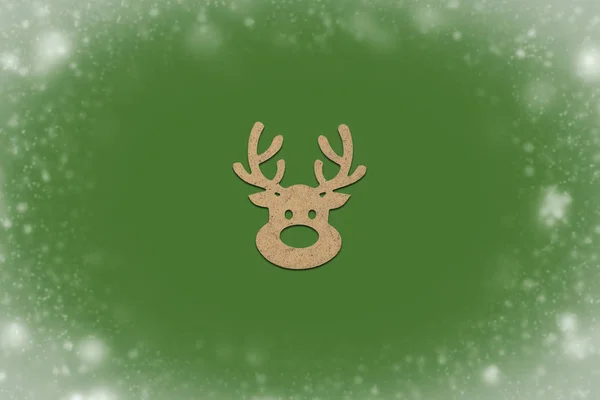 Wooden Christmas toy Deer head on a green isolated background wi — Stock Photo, Image