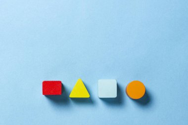 Çocukların eğitici oyuncakları geometrik şekiller mavi arka planda mantık için. Eğitim, çocuk gelişimi, mantık ve yaratıcılık kavramı. Düz yatış, üst görünüm