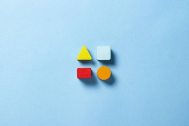 Çocukların eğitici oyuncakları geometrik şekiller mavi arka planda mantık için. Eğitim, çocuk gelişimi, mantık ve yaratıcılık kavramı. Düz yatış, üst görünüm