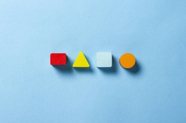 Çocukların eğitici oyuncakları geometrik şekiller mavi arka planda mantık için. Eğitim, çocuk gelişimi, mantık ve yaratıcılık kavramı. Düz yatış, üst görünüm