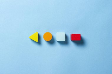 Çocukların eğitici oyuncakları geometrik şekiller mavi arka planda mantık için. Eğitim, çocuk gelişimi, mantık ve yaratıcılık kavramı. Düz yatış, üst görünüm