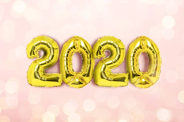Golden Air μπαλόνια αριθμούς 2020 σε ένα ροζ φόντο με bokeh από εορταστικά φώτα. Η έννοια της Πρωτοχρονιάς, παραμονή Πρωτοχρονιάς, χειμερινές διακοπές. Επίπεδο lay, πάνω όψη — Φωτογραφία Αρχείου