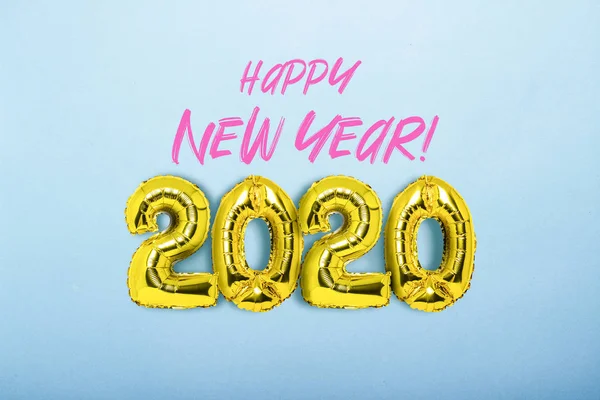Globos de aire dorados números 2020 sobre un fondo azul. Texto añadido. El concepto del Año Nuevo, la víspera de Año Nuevo, las vacaciones de invierno. Piso tendido, vista superior —  Fotos de Stock