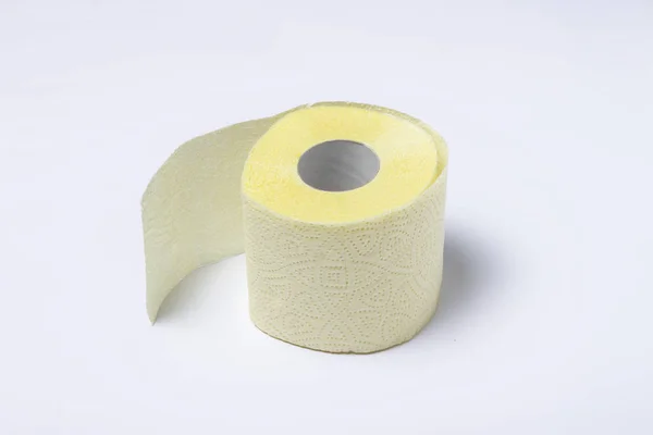 Rolo de papel higiênico amarelo sobre um fundo branco. Conceito de higiene pessoal. Deitado plano, vista superior — Fotografia de Stock