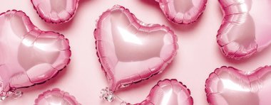 Pembe arka planda kalp şeklinde pembe hava balonları. Sevgililer Günü için konsept, dekorasyon, düğün, davetiye ya da fotoğraf bölgesi. Folyo topları. Pankart. Düz yatış, üst görünüm