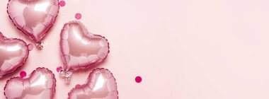 Pembe arka planda kalp şeklinde pembe hava balonları. Sevgililer Günü için konsept, dekorasyon, düğün, davetiye ya da fotoğraf bölgesi. Folyo topları. Pankart. Düz yatış, üst görünüm